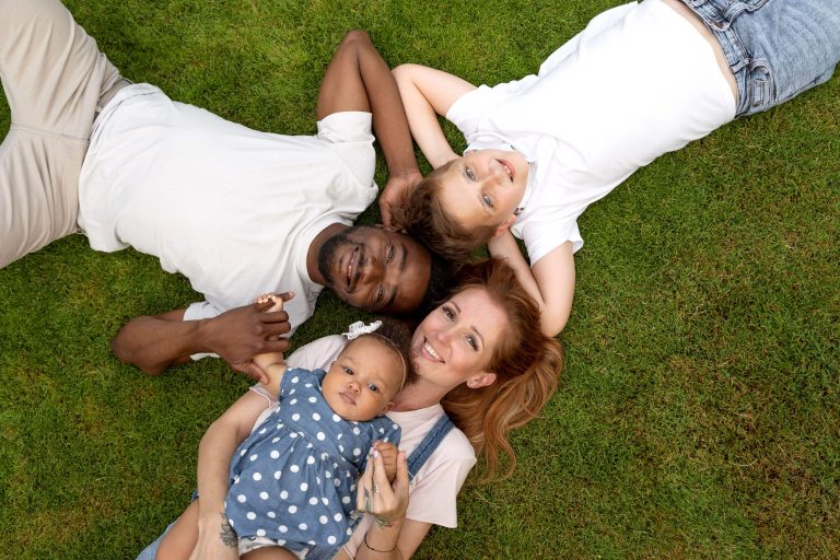 Mixed Race Blended Family Lying On Grass In A Circle, Birds-Eye View